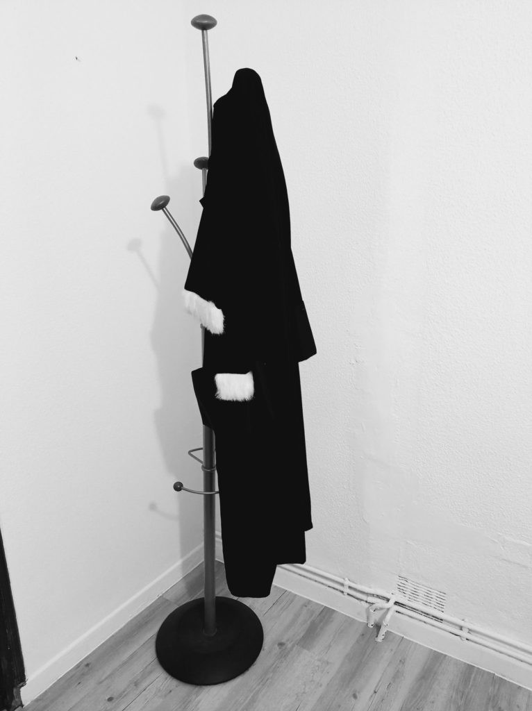 robe d'avocat accrochée à un porte manteau - en noir et blanc